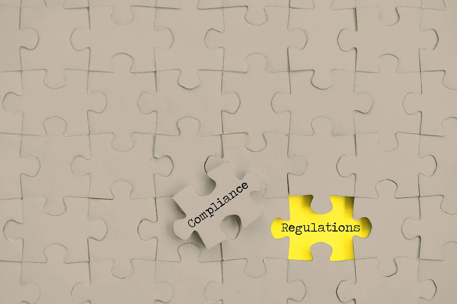 Puzzle with compliance piece removed revealing yellow regulations piece underneath