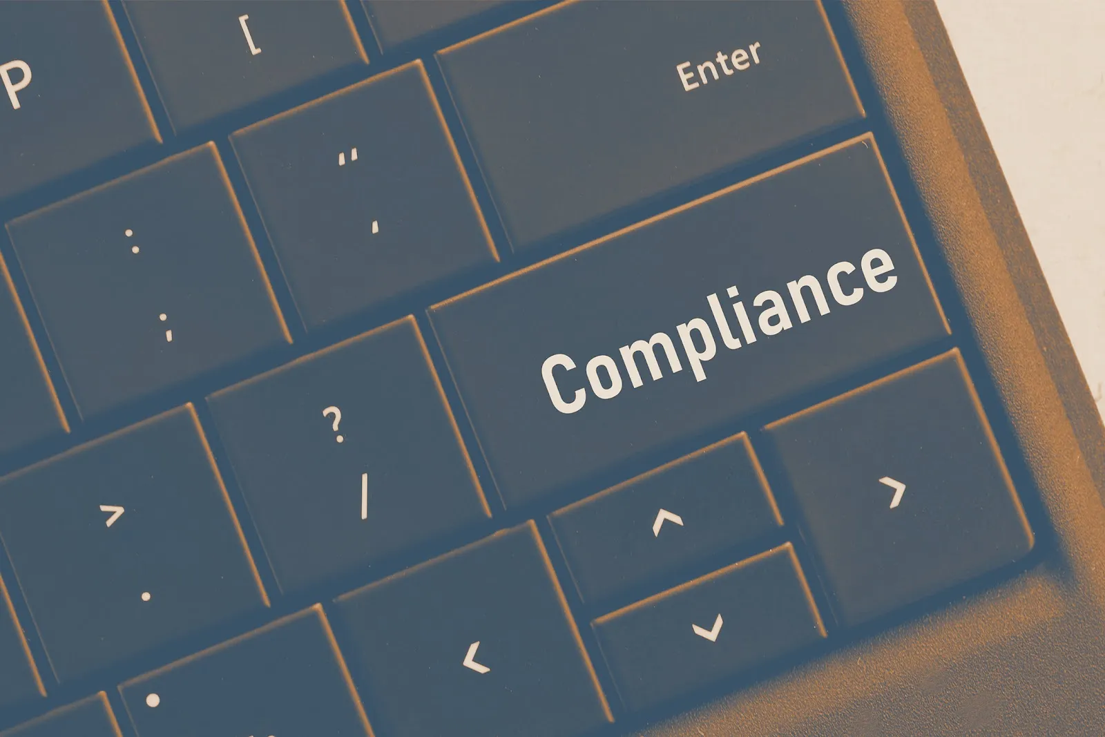 Close-up of computer keyboard with a key labeled Compliance replacing the standard key