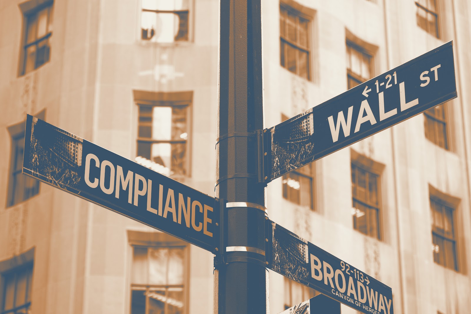 Street sign post at intersection of Compliance, Wall St, and Broadway in New York City financial district